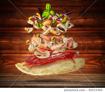 Flying ingredients with pizza dough, on wooden background 40415464