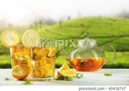 Cups of ice tea with plantation on background 40416747