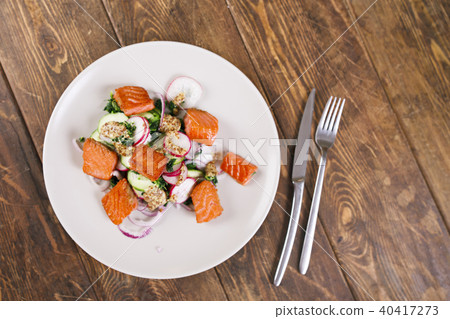 Grilled salmon with radish and spinach, served on white plate. View from above, top studio shot 40417273