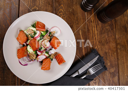 Grilled salmon with radish and spinach, served on white plate. View from above, top studio shot 40417301
