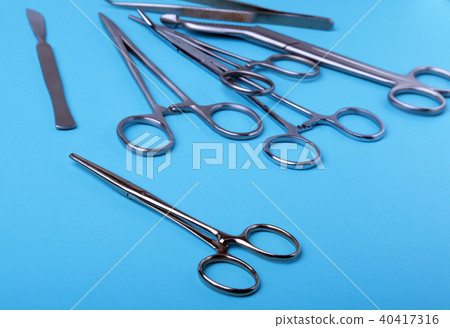 surgical instruments and tools including scalpels, forceps and tweezers arranged on a table for a surgical instruments and tools including scalpels, forceps and tweezers arranged on a table for a 40417316