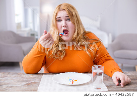 Unhappy stout woman taking medications Unhappy stout woman taking medications 40422597