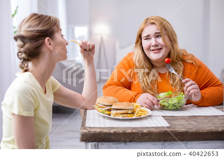 Miserable plump woman having lunch with her friend 40422653