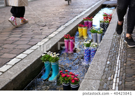 Rubber boots in the water with flowers in the city of Freiburg. Tourist attraction. Rubber boots in the water with flowers in the city of Freiburg. Tourist attraction. 40423841