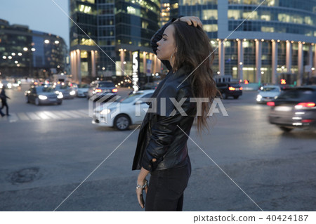 Beautiful woman on a background of a night city and passing cars. Beautiful woman on a background of a night city and passing cars. 40424187
