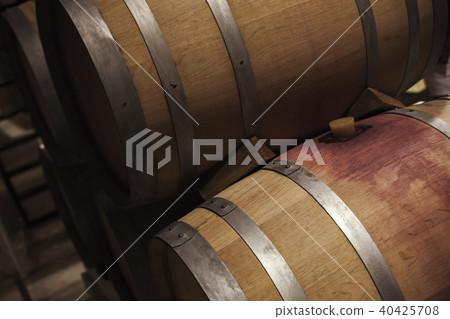 Wooden barrels with red wine in dark winery 40425708