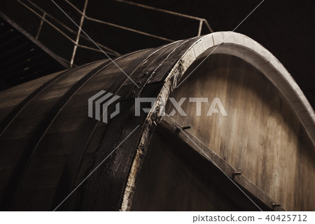 Old wooden barrel in dark winery, close up Old wooden barrel in dark winery, close up 40425712