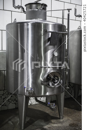 Steel barrel with manometer stands in winery 40425721