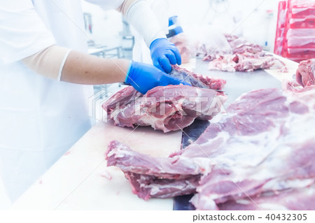 butcher cutting the fresh meat in ham factory butcher cutting the fresh meat in ham factory 40432305