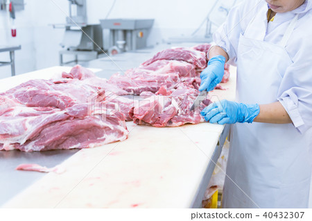butcher cutting the fresh meat in ham factory 40432307