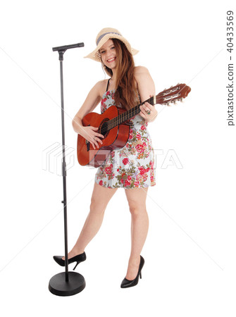 Pretty woman playing guitar and singing 40433569