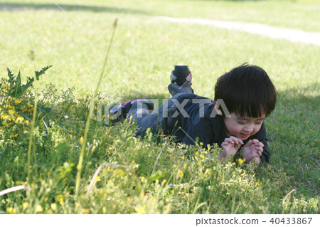 Photo of a boy playing in a park grass Photo of a boy playing in a park grass 40433867
