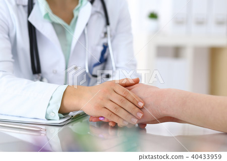 Hand of doctor reassuring to female patient, closeup. Medical ethics and trust concept 40433959