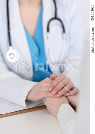 Medicine doctor hand reassuring her female patient closeup. Medicine, comforting  and trustin 40433963