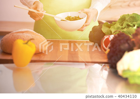 Close Up of human hands cooking vegetable salad in kitchen on the glass table with reflection 40434110