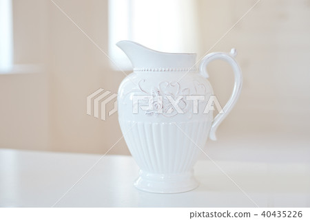 Big white ceramic jug on the table in big bright room Big white ceramic jug on the table in big bright room 40435226