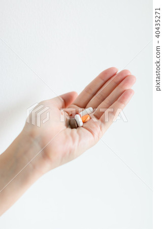 Right hand is holding tablet medicines. 40435271