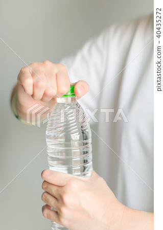 A woman try to open drinking water bottle. 40435272