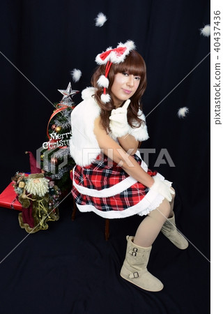 聖誕老人女孩服裝全身女人坐在椅子上,左手食指女人與清晰的臉 聖誕老人女孩服裝全身女人坐在椅子上,左手食指女人與清晰的臉 40437436