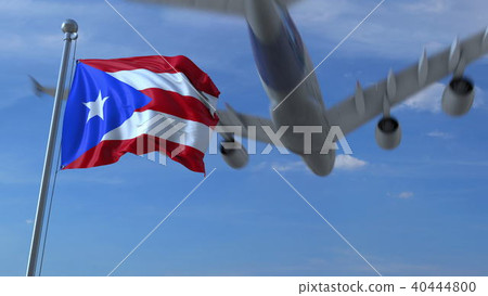 Commercial airplane flying above waving flag of Puerto Rico. 3D rendering Commercial airplane flying above waving flag of Puerto Rico. 3D rendering 40444800