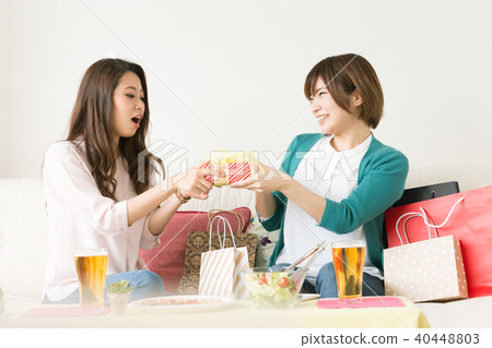 A woman giving a gift for a friend A woman giving a gift for a friend 40448803