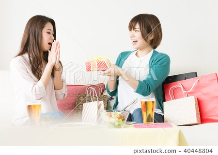 A woman giving a gift for a friend A woman giving a gift for a friend 40448804