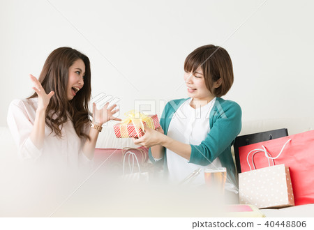 A woman giving a gift for a friend A woman giving a gift for a friend 40448806