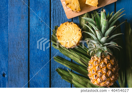 Pineapple fruit with slices on a blue wooden table Pineapple fruit with slices on a blue wooden table 40454027