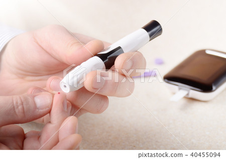 Man Pierce his fingertip before doing blood test 40455094