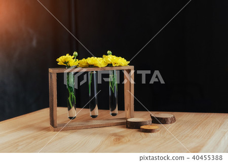 Bright yellow daisies in a glass vase on wooden sword. Bright yellow daisies in a glass vase on wooden sword. 40455388