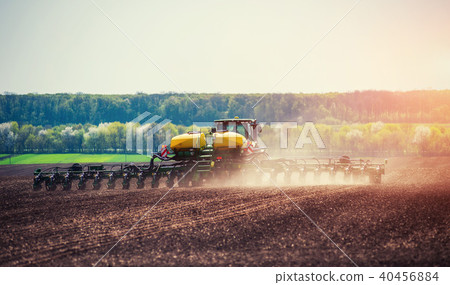 Tractor plowing farm field in preparation for spring planting 40456884