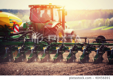Tractor plowing farm field in preparation for spring planting 40456891