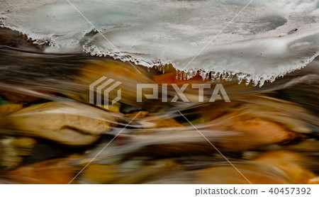 River runs swiftly under growing shelf of ice River runs swiftly under growing shelf of ice 40457392