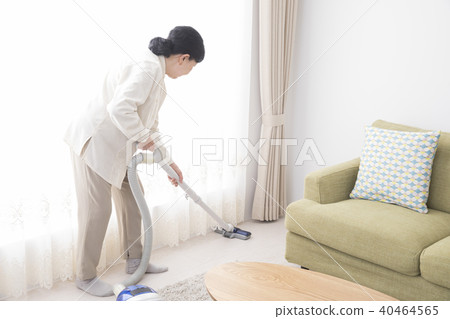 Senior woman vacuuming 40464565