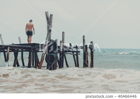 Man standing at the pier and watching the ocean Man standing at the pier and watching the ocean 40466446