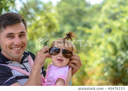 Amazing little girl is playing with sunglasses with her father Amazing little girl is playing with sunglasses with her father 40476153