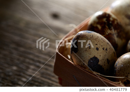 Quail eggs in a box on a vintage wooden background, top view, shallow depth of field, backlight. Quail eggs in a box on a vintage wooden background, top view, shallow depth of field, backlight. 40481779