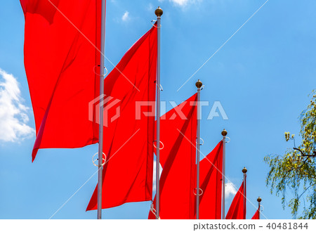 Red flags waving on the blue sky background Red flags waving on the blue sky background 40481844