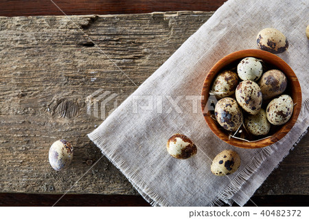 Bowl with eggs quail, eggs on a homespun napkin on wooden background, close-up, selective focus Bowl with eggs quail, eggs on a homespun napkin on wooden background, close-up, selective focus 40482372