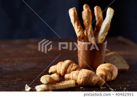 Puff pastries on dark wooden table, close-up, selective focus, backlight. 40482951