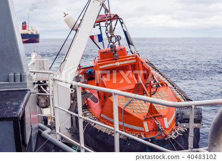 Lifeboat or FRC rescue boat in the vessel at sea. Tanker ship is on background 40483102