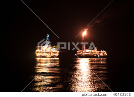 FPSO tanker vessel near Oil Rig at night. Offshore oil and gas industry 40483108