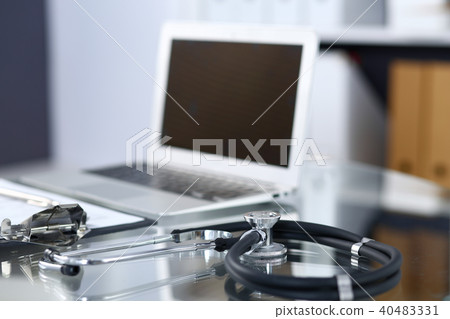 Stethoscope, prescription medical form lying on glass table with laptop computer. Medicine or Stethoscope, prescription medical form lying on glass table with laptop computer. Medicine or 40483331
