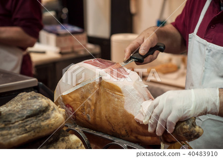 closeup of man cutting smoked ham at the market closeup of man cutting smoked ham at the market 40483910
