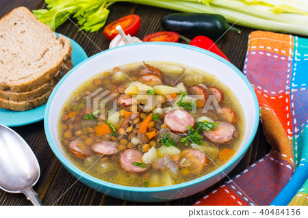Soup with lentils, celery and sausages on old wooden table Soup with lentils, celery and sausages on old wooden table 40484136