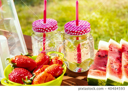 two glasses of lemonade and fruit on a picnic table two glasses of lemonade and fruit on a picnic table 40484593