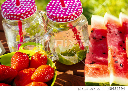 two glasses of lemonade and fruit on a picnic table two glasses of lemonade and fruit on a picnic table 40484594