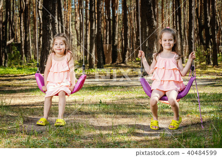 little girls are swinging on swings 40484599