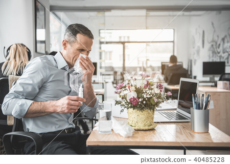 Disappointed sick employer working with laptop Disappointed sick employer working with laptop 40485228