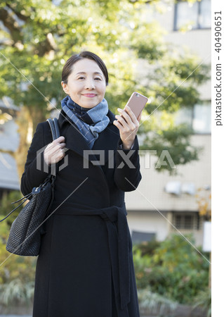 Outdoor mature woman and smartphone Outdoor mature woman and smartphone 40490651